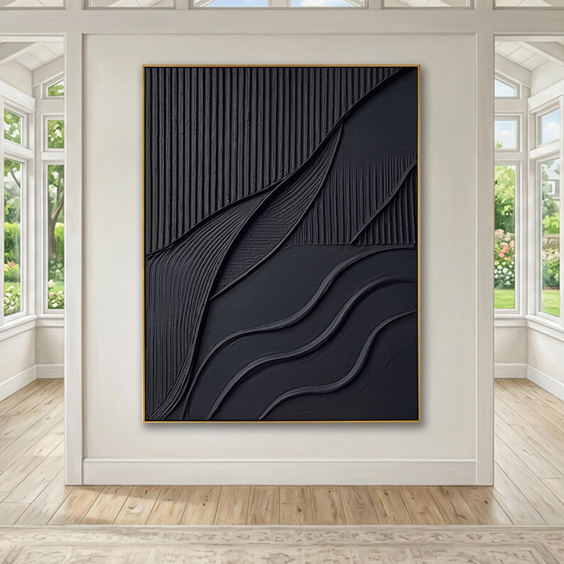 The large, textured black abstract artwork with a gold frame is mounted on a light beige focal wall. The surrounding space is a grand, high-ceilinged room filled with natural light from symmetrical windows on both sides that look out onto a green garden. The room features light wood plank flooring and a neutral, modern aesthetic.