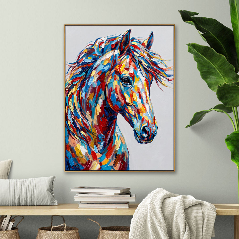 Hand-painted colorful horse canvas artwork hung above a wooden console table with books.