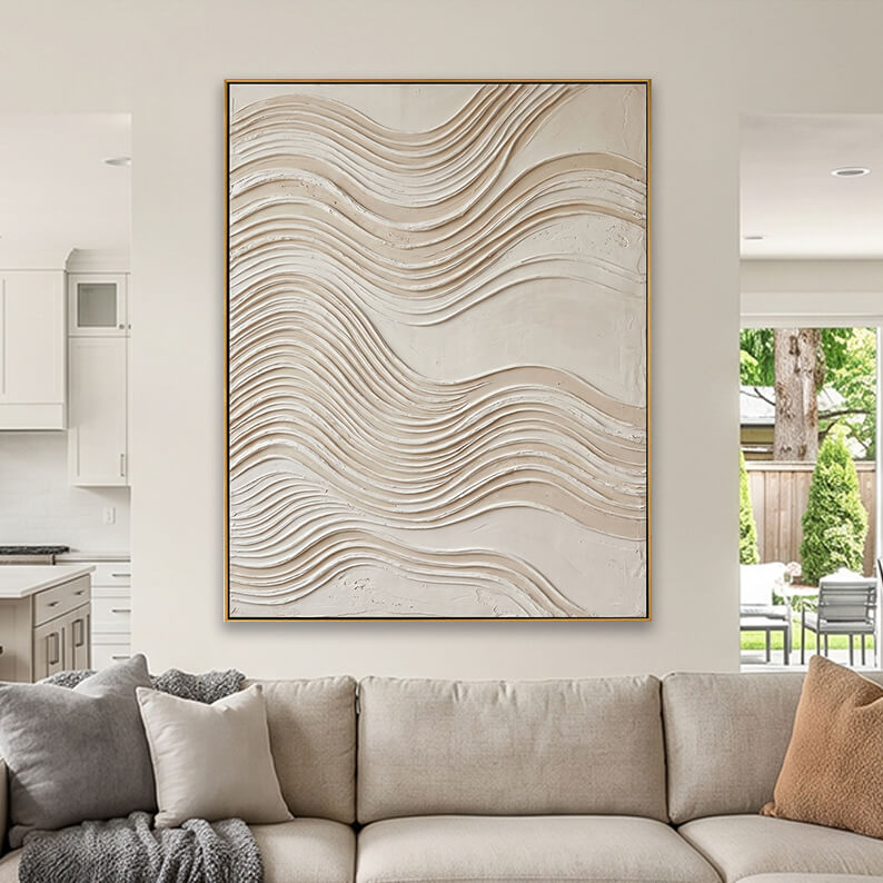 Cream colored heavily textured abstract canvas art styled above a beige fabric sofa in a neutral living room.