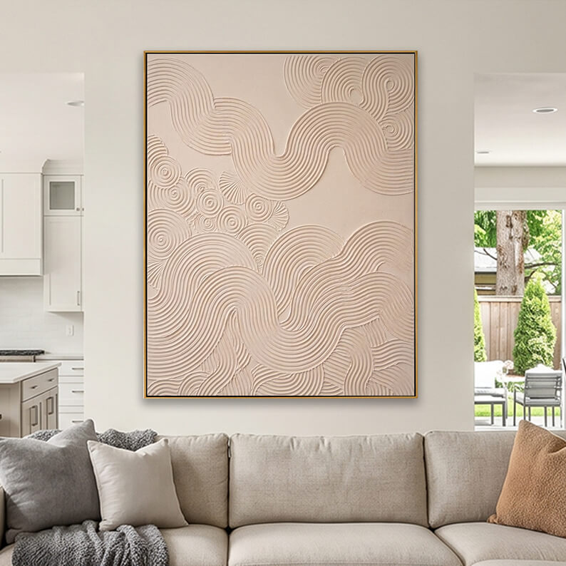 Cream colored heavily textured abstract canvas art styled above a beige fabric sofa in a neutral living room.