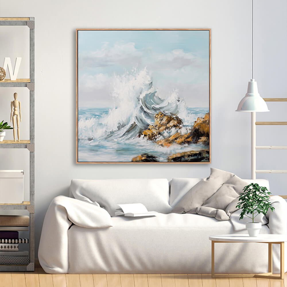 Bold rocky crashing wave seascape painting above cream linen minimalist sofa