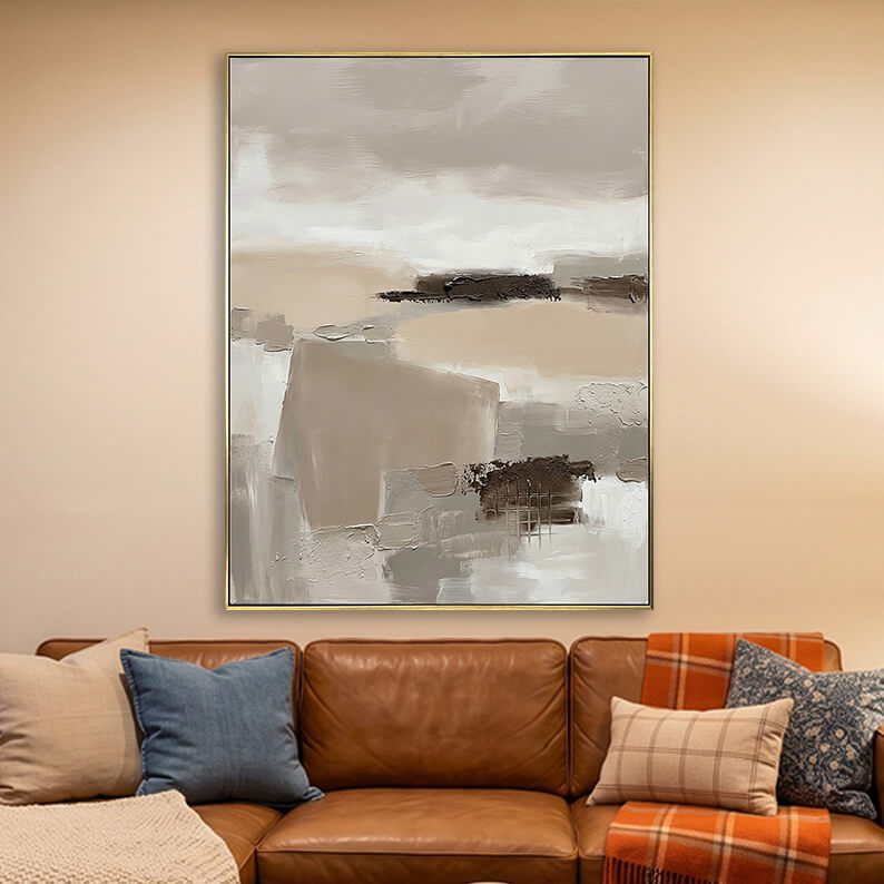 Beige grey and brown 3D textured abstract painting hanging above a brown leather sofa in a warm modern living room.
