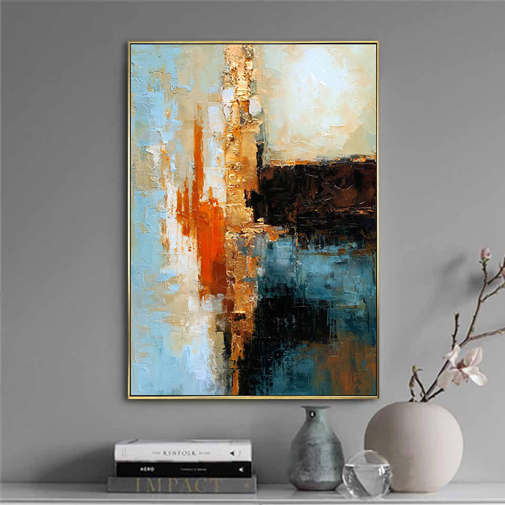 Minimal grey wall scene, vertical blue & gold textured abstract canvas displayed above books and ceramic vases