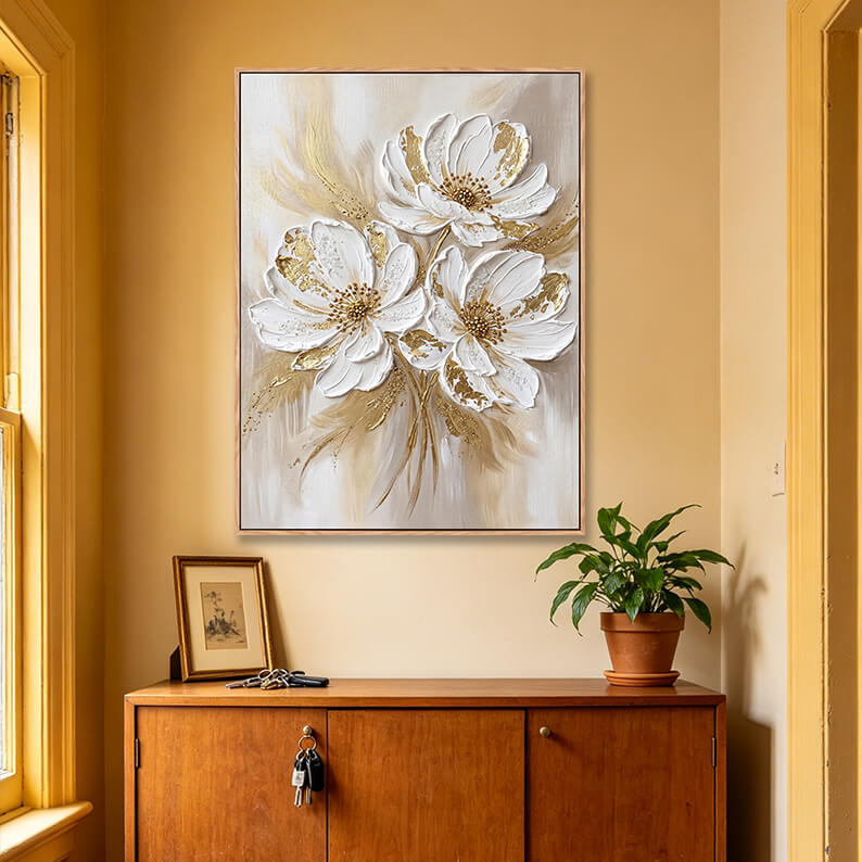 Vertical three white flowers 3D painting with gold accents above wooden sideboard, heavy impasto floral artwork for home entryway decor