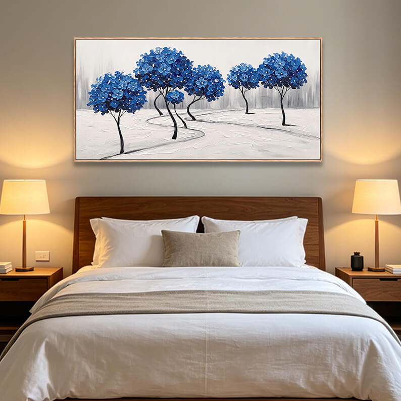Panoramic horizontal textured blue tree grove painting hanging elegantly above a dark wood headboard bed in a modern neutral bedroom.