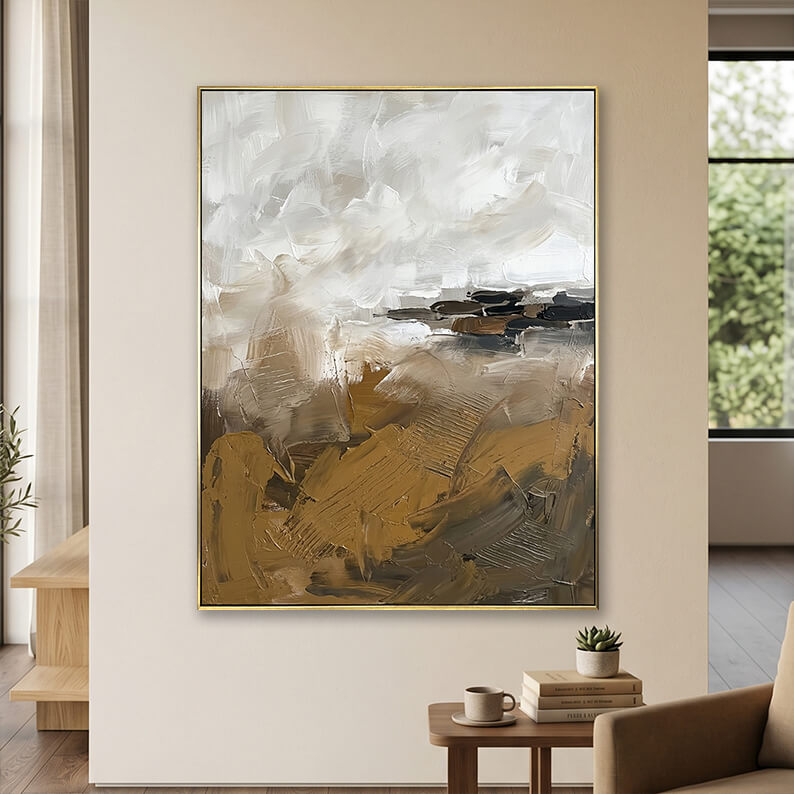 Minimalist beige white and brown 3D textured canvas art displayed on a neutral wall above a small wooden table with books.