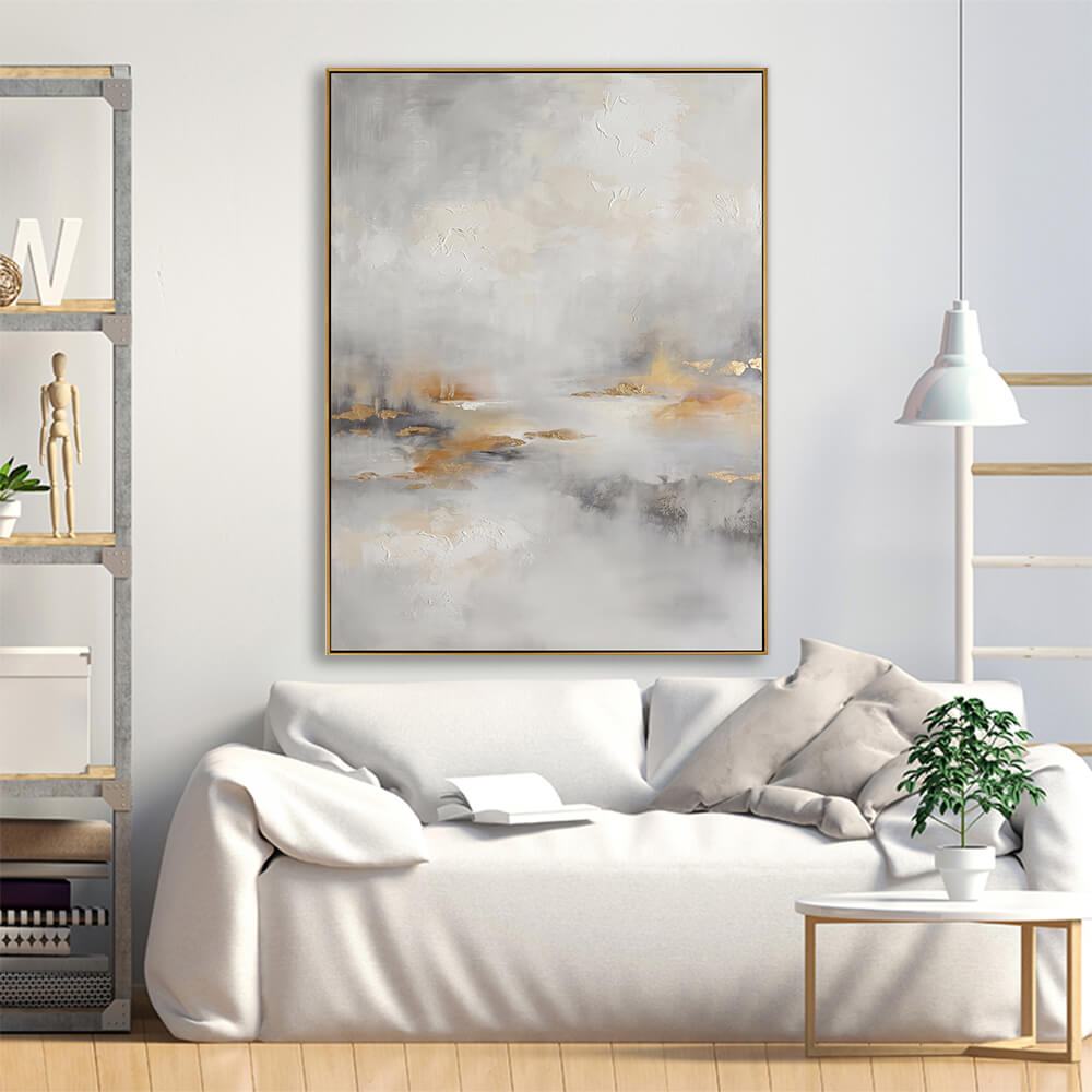 Hand-painted fog gold leaf abstract canvas displayed above cream linen sofa in bright neutral modern living room