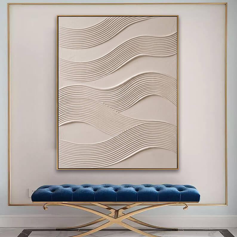 Modern textured wave canvas art displayed above a tufted blue velvet bench in an elegant entryway.