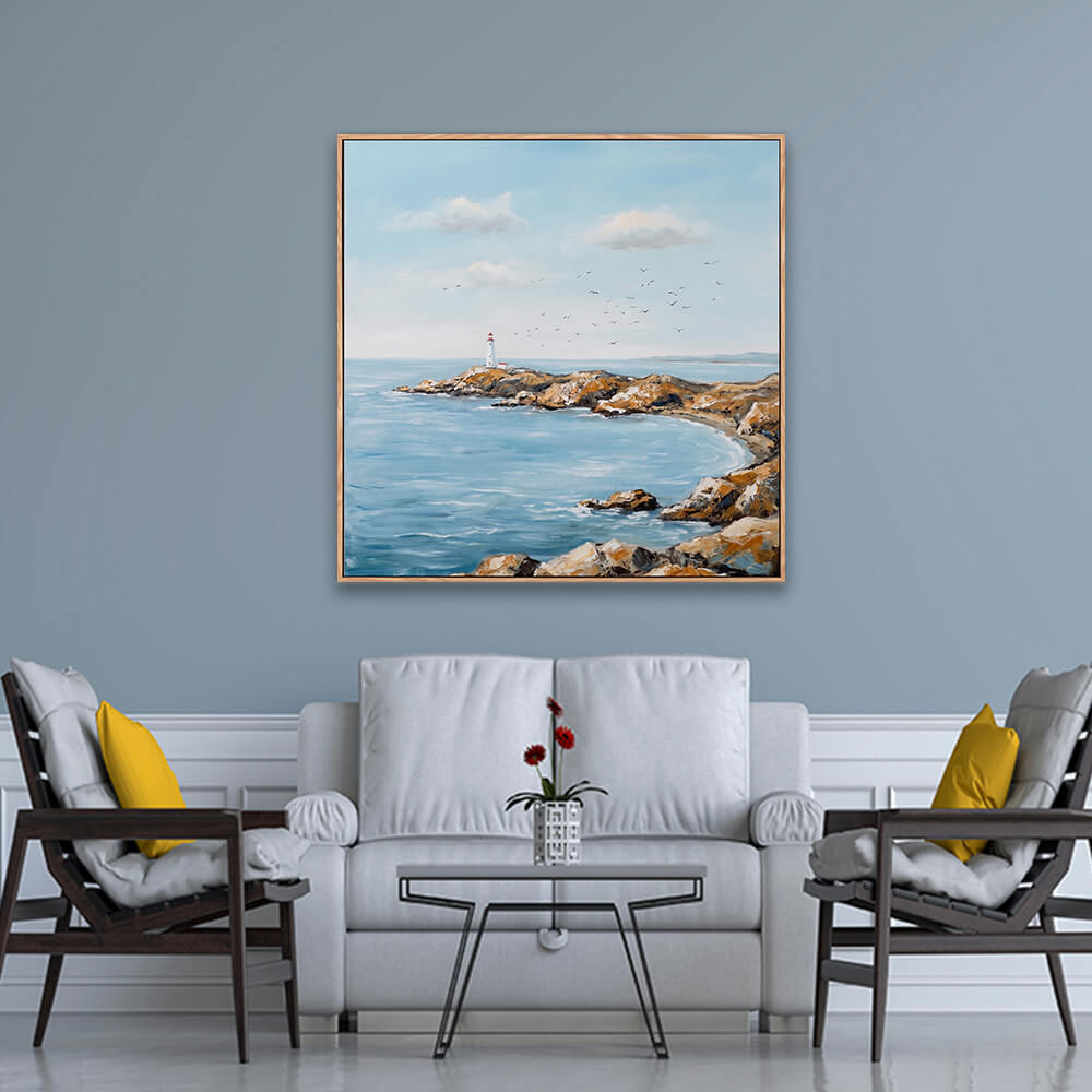 Gentle cove lighthouse coastal landscape artwork hanging on light blue formal living room wall