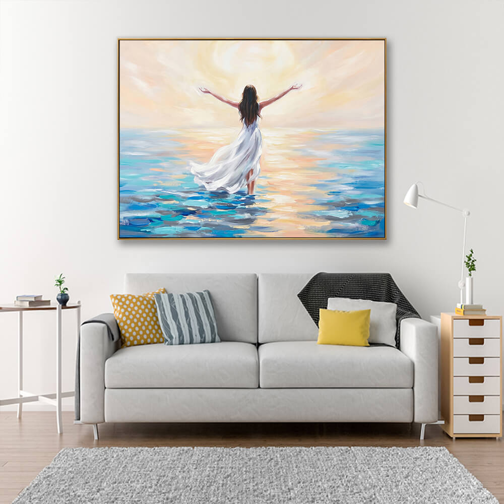 Peaceful impressionist sunrise ocean canvas wall art hanging above light grey fabric sofa in soft neutral living room