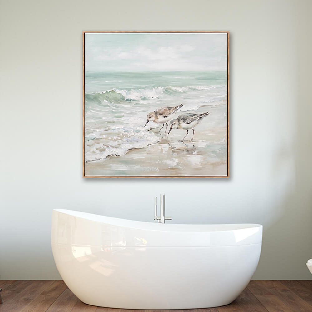 Framed sandpiper beach seascape wall art hung above modern freestanding bathtub