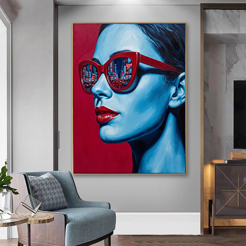 Striking blue red pop art portrait canvas hanging in calm grey modern lounge with blue textured accent armchair and marble side cabinet