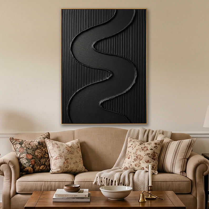Tactile black abstract painting styled in a cozy living room setting with warm wooden furniture.