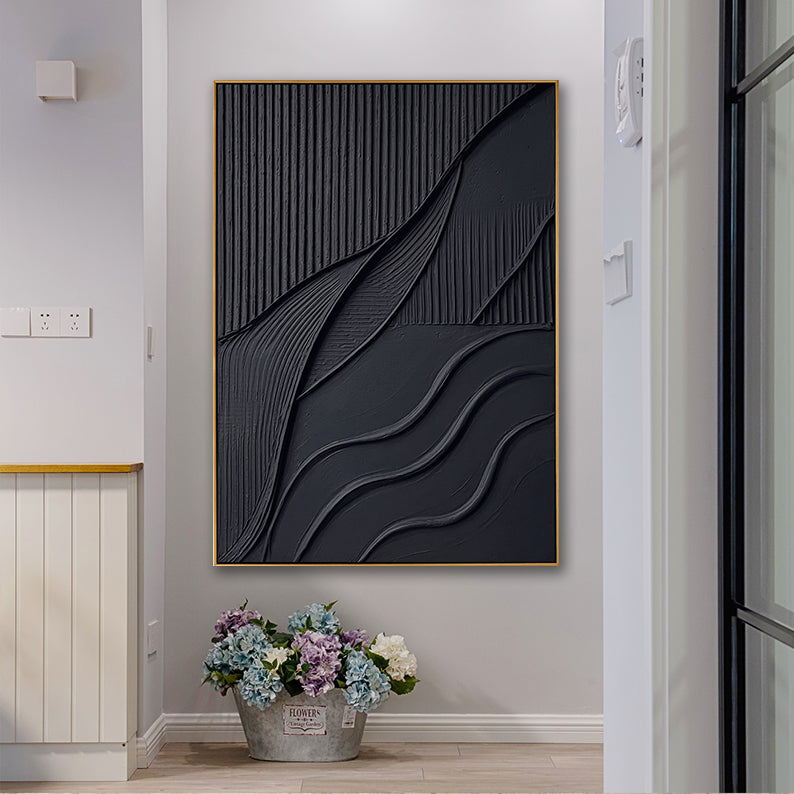 Contemporary black 3D plaster-style painting situated above a bucket of purple and blue hydrangeas.