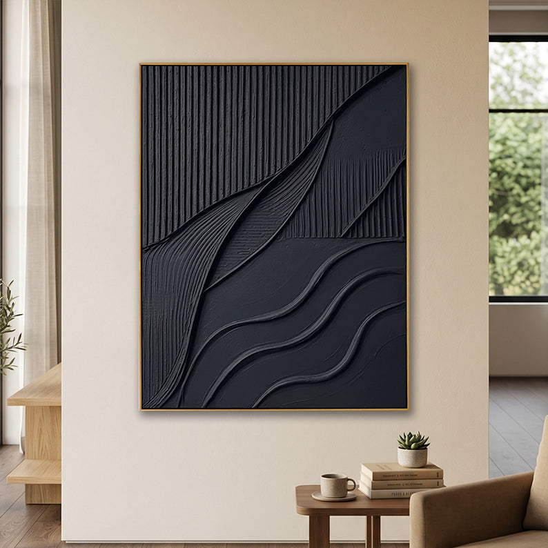Monochromatic black textured wall decor in a warm neutral living room above a wooden side table with a coffee cup.