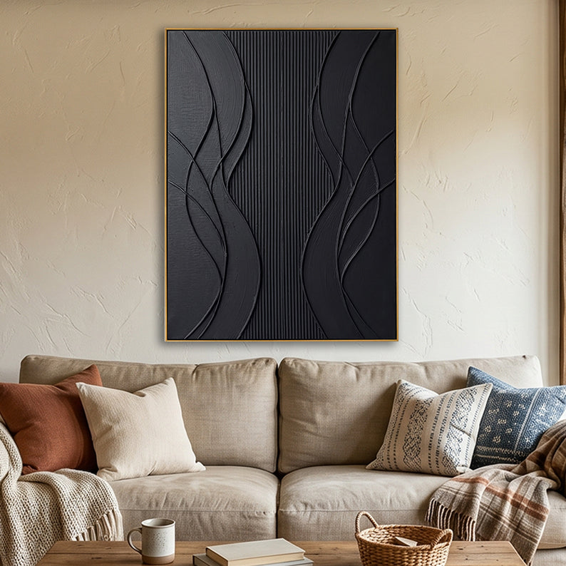 Matte black 3D wall decor displayed above a beige sofa with warm-toned accent pillows.