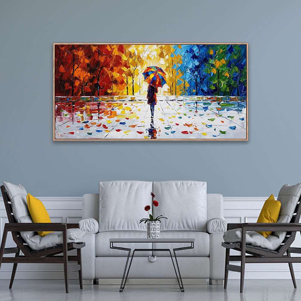 Panoramic colorful abstract autumn landscape painting featuring a figure with an umbrella, styled in a grey and white modern living room above a white couch.