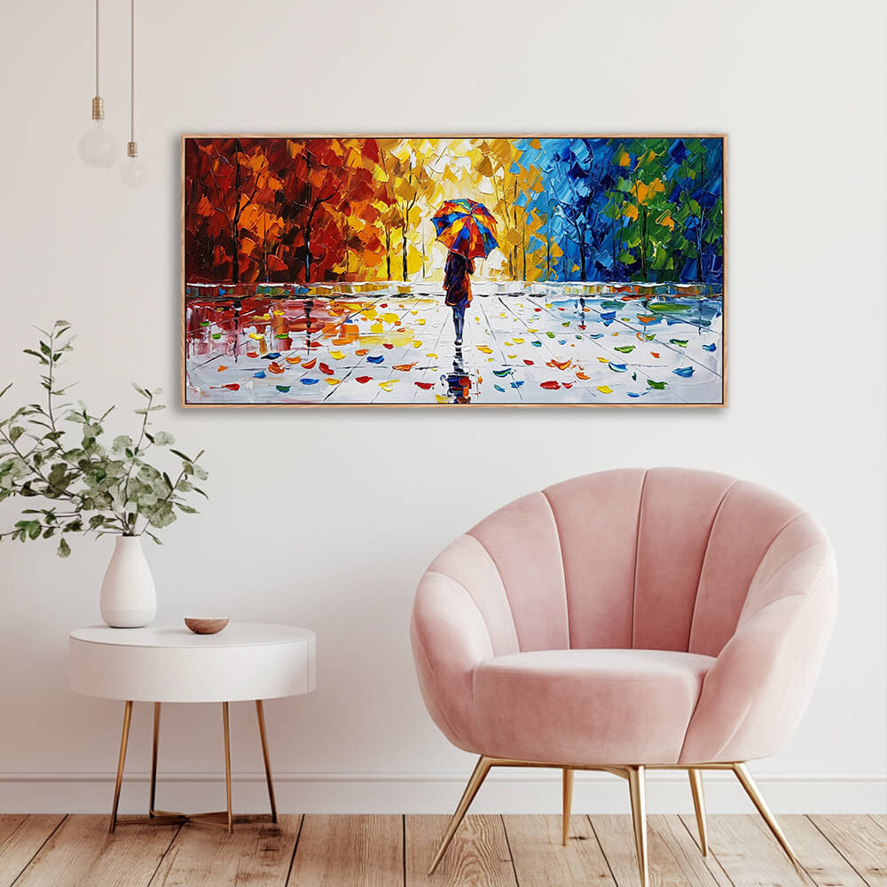 Vibrant red, yellow, and blue landscape palette knife canvas styled in a contemporary light room next to a soft pink armchair.