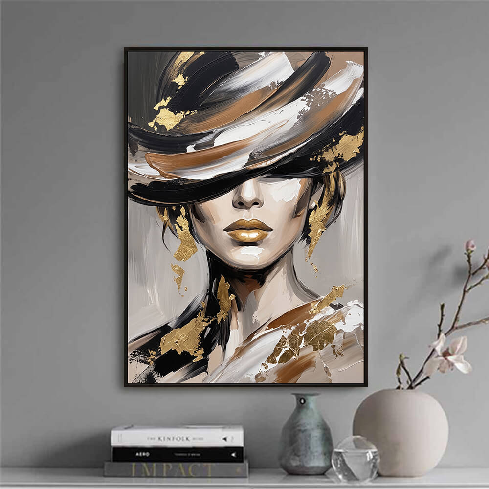 Minimalist interior decor vignette displaying a framed original oil painting of a woman's face next to curated books and a ceramic vase.