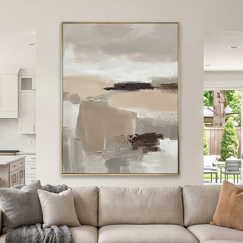 Beige and taupe heavily textured abstract canvas art styled above a beige fabric sofa in a neutral living room.