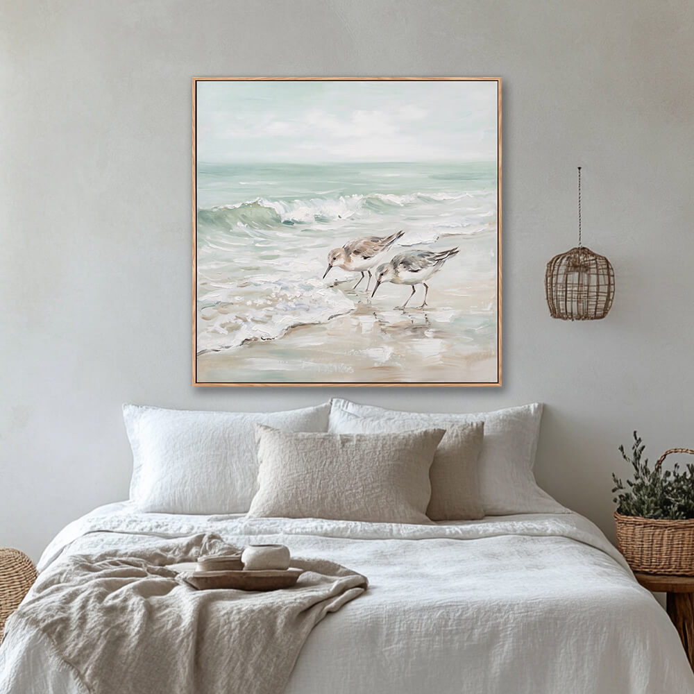 Calm sandpiper beach landscape wall art above linen bed in cozy neutral bedroom