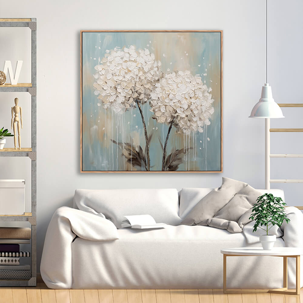 Textured white hydrangea floral artwork above white sofa in modern living room