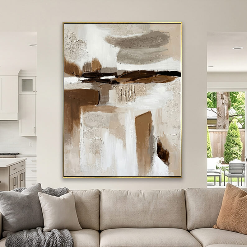 Beige and brown heavily textured abstract canvas art styled above a beige fabric sofa in a neutral living room.