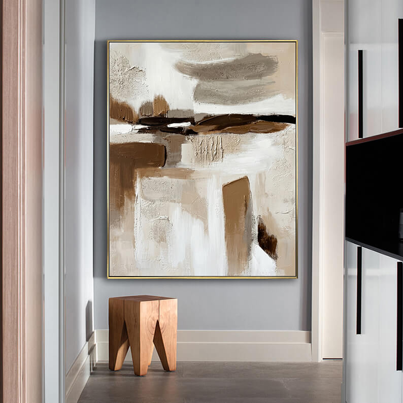 Abstract geometric 3D texture painting hanging above a geometric wooden stool in a minimalist modern hallway.