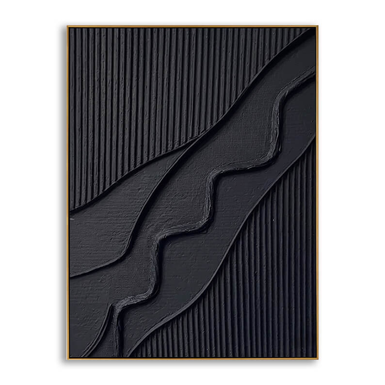 A close-up product shot of a rectangular, modern 3D abstract painting. The artwork is entirely matte black, enclosed in a slim, elegant gold frame. The composition is divided into three distinct textured layers: the top-left and bottom-right sections are textured with dense, neat, vertical ridges. Sweeping diagonally across the center is a thick, organic, wavy ribbon of heavy plaster or impasto paint, creating a dramatic sense of depth, shadow, and sculptural form on the canvas.