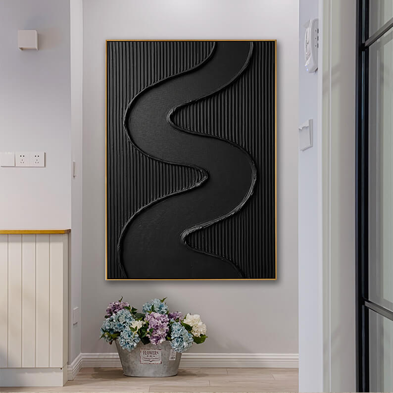 The minimalist black and gold textured painting hangs in a clean, light grey hallway. On the floor directly beneath the artwork, a rustic zinc flower bucket is filled with a vibrant arrangement of blue, purple, and white hydrangeas. A modern black-framed glass sliding door is visible on the right.