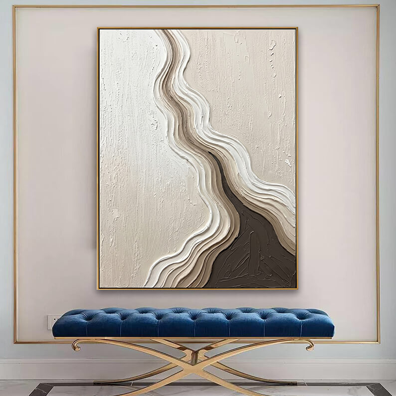 Oversized neutral abstract canvas art with heavy 3D texture displayed elegantly above a luxurious blue velvet tufted bench.