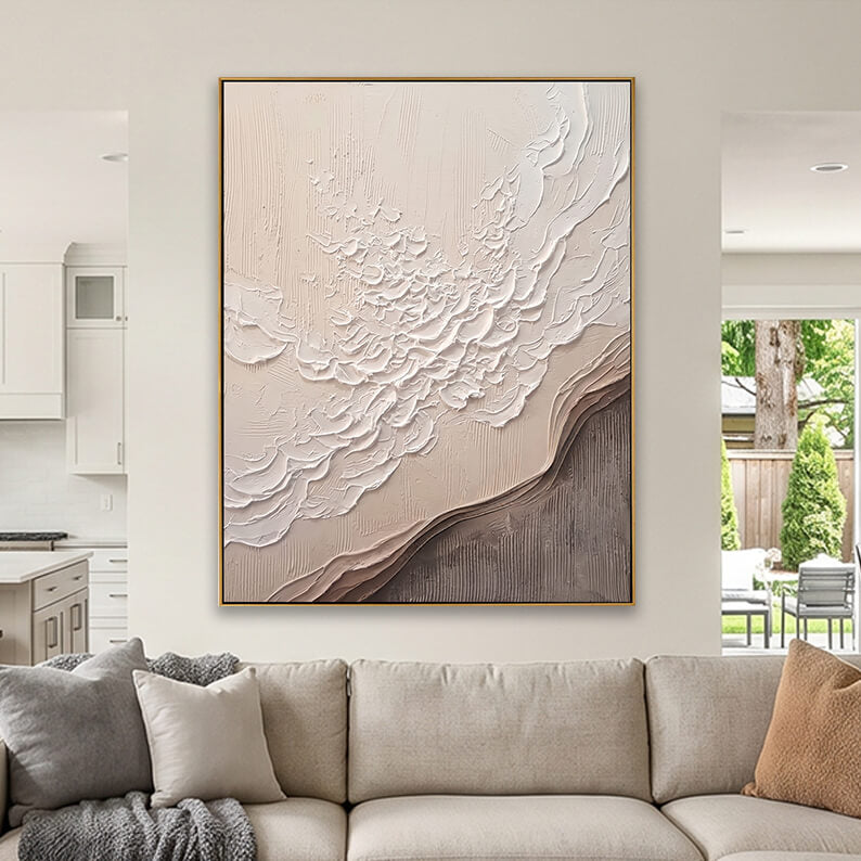 Modern beige and taupe textured abstract art hanging above a contemporary sofa in a neutral living room.