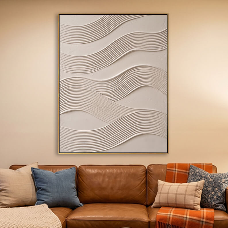 Beige 3D textured ripple wave painting hanging above a brown leather sofa in a warm modern living room.