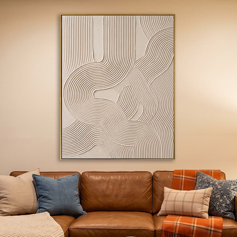 Beige 3D textured geometric line painting hanging above a brown leather sofa in a warm modern living room.