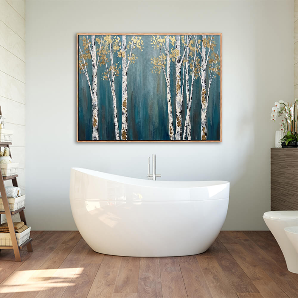 Modern bathroom interior, framed horizontal teal blue birch tree wall art, white trunk golden leaf woodland canvas above freestanding tub