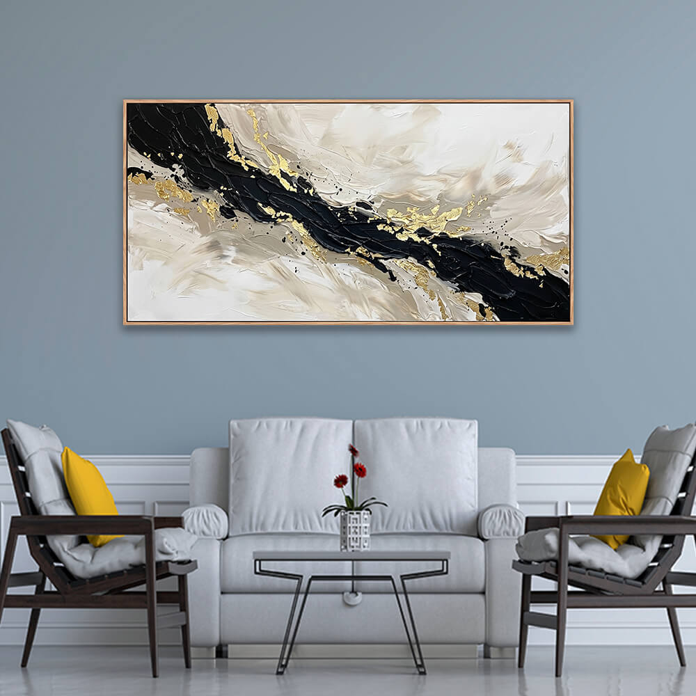 Horizontal black and gold textured abstract painting hanging above a white sofa with yellow pillows in a modern grey living room.