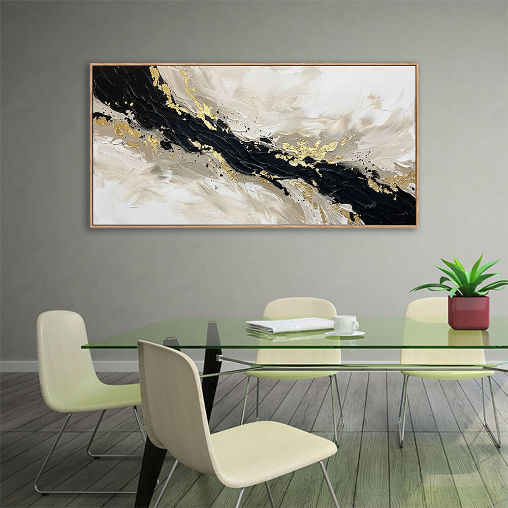 Contemporary textured black and cream abstract artwork with gold leaf hanging in a dining room with a green glass table.