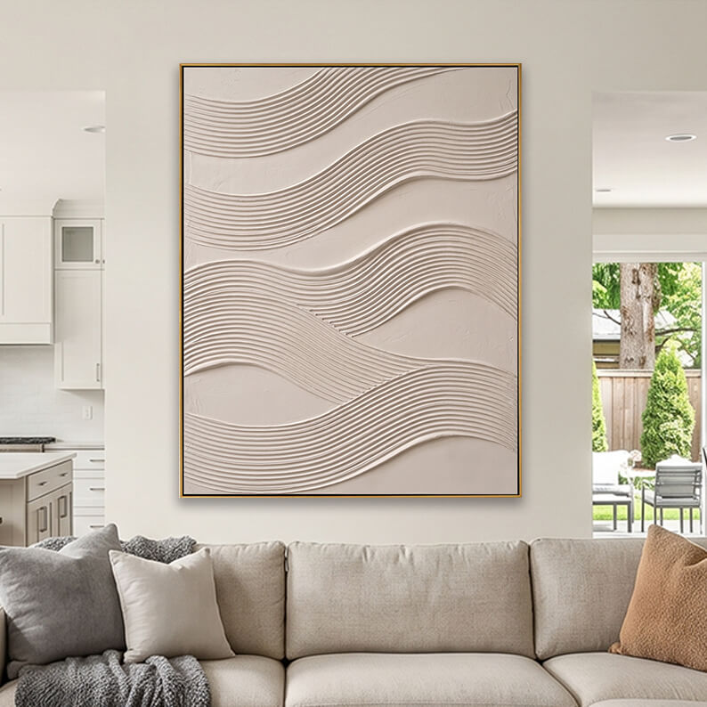 Cream colored heavily textured abstract canvas art styled above a beige fabric sofa in a neutral living room.