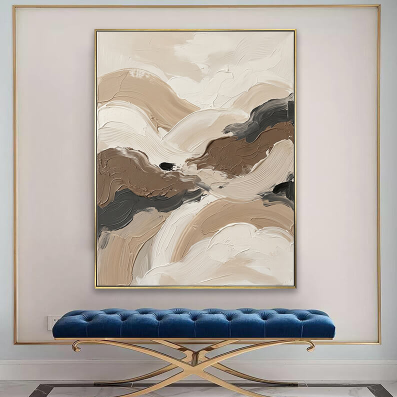 Modern textured brown and beige canvas art displayed above a tufted blue velvet bench in an elegant entryway.