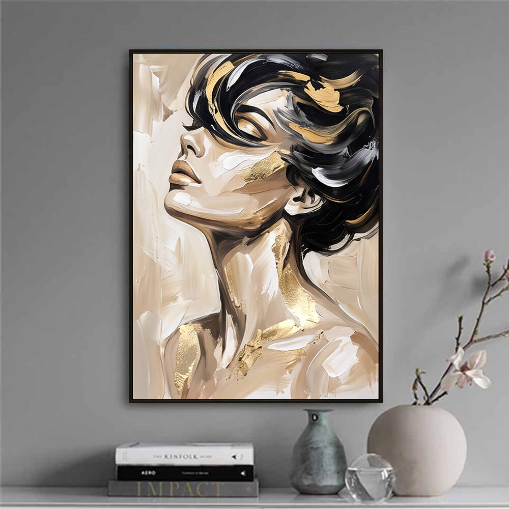 Minimalist interior decor vignette displaying a framed original oil painting of a woman's face next to curated books and a ceramic vase.