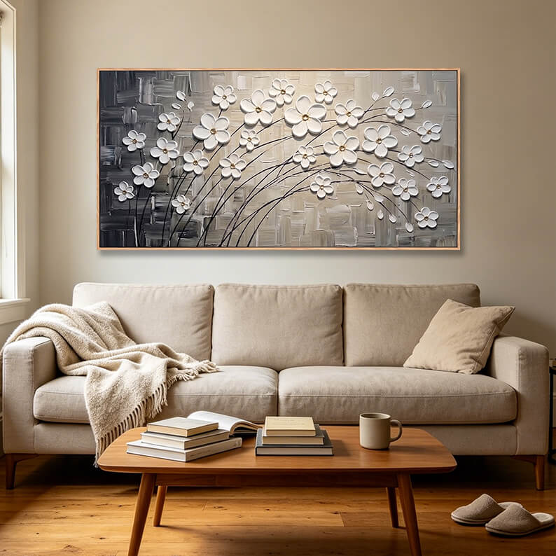 Hand-painted 3D white cherry blossom landscape canvas styled in a modern, neutral-toned living room above a beige sofa.