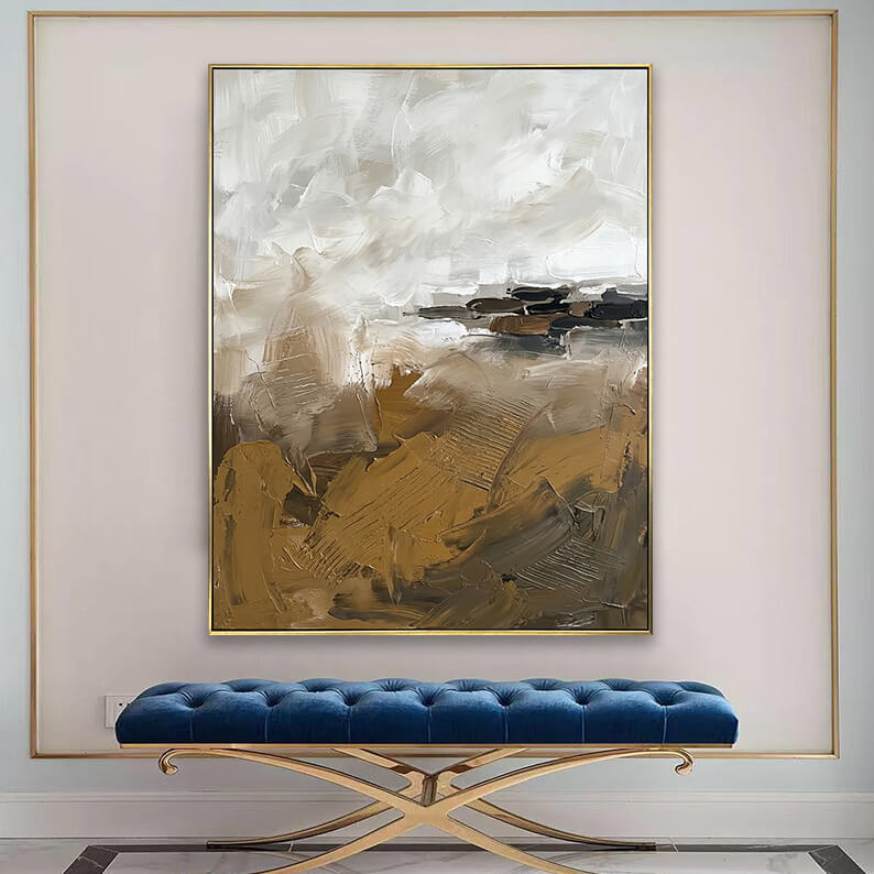 Modern textured brown and beige canvas art displayed above a tufted blue velvet bench in an elegant entryway.
