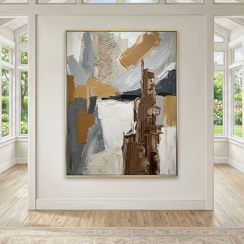 Grey and brown heavily textured abstract canvas art styled above a beige fabric sofa in a neutral living room.