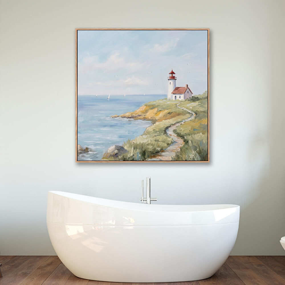 Framed cliffside lighthouse ocean seascape wall art hung above modern freestanding bathtub