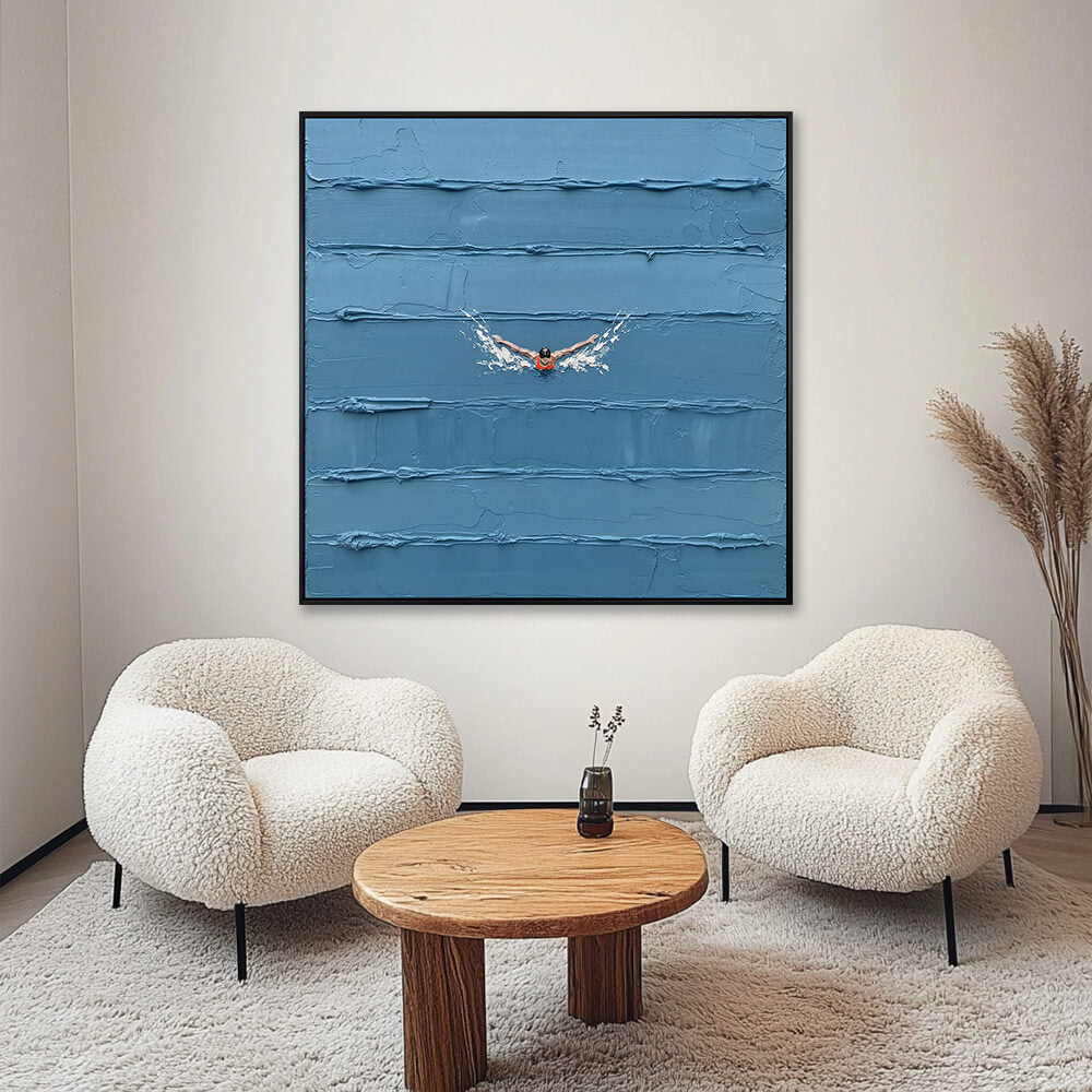 Interior styling view of Solitary Stroke hanging in a cozy, cream-colored living room between two fluffy chairs and a wooden coffee table.