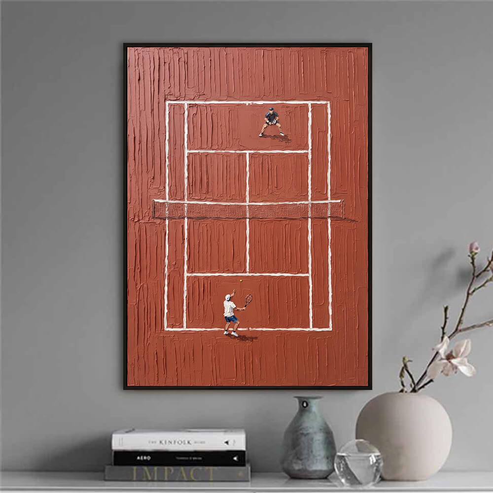 Interior styling view of Red Clay Tennis Court textured clay court painting art hanging above a table set with books and a vase.