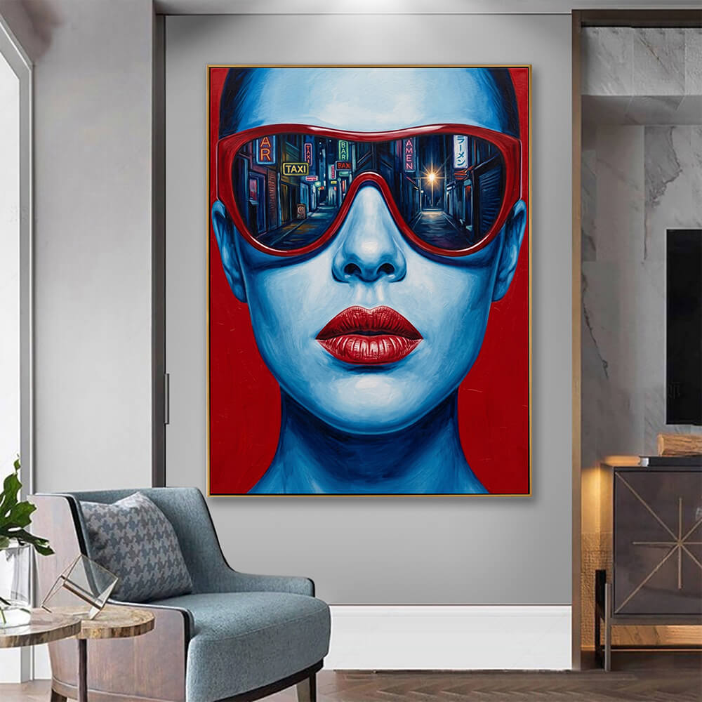 Striking red blue pop art portrait canvas hanging in minimalist grey lounge, next to blue textured armchair and marble side cabinet with warm ambient lighting