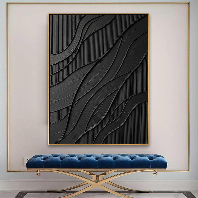 Large black 3D textured abstract painting displayed above a blue velvet bench in a modern entryway.