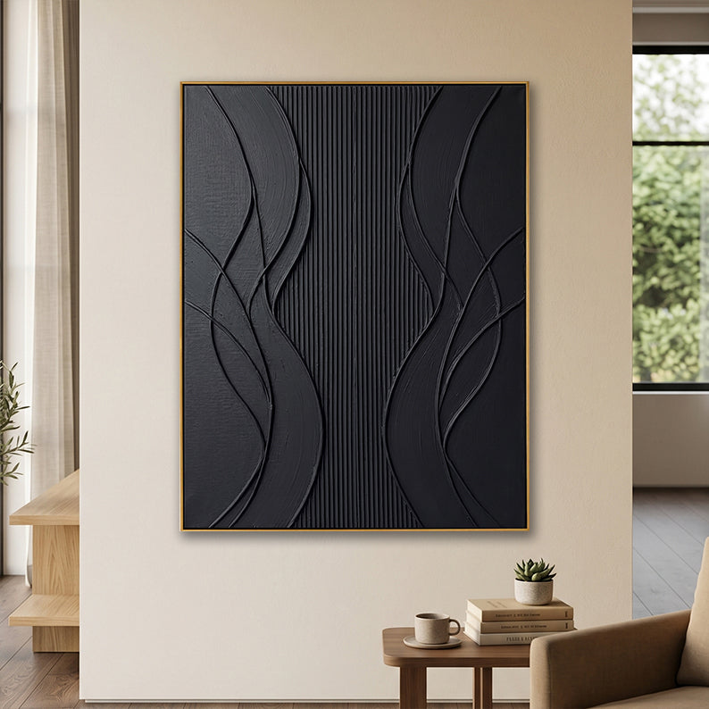 Contemporary black textured canvas art in a minimalist living room setting with a wooden side table.