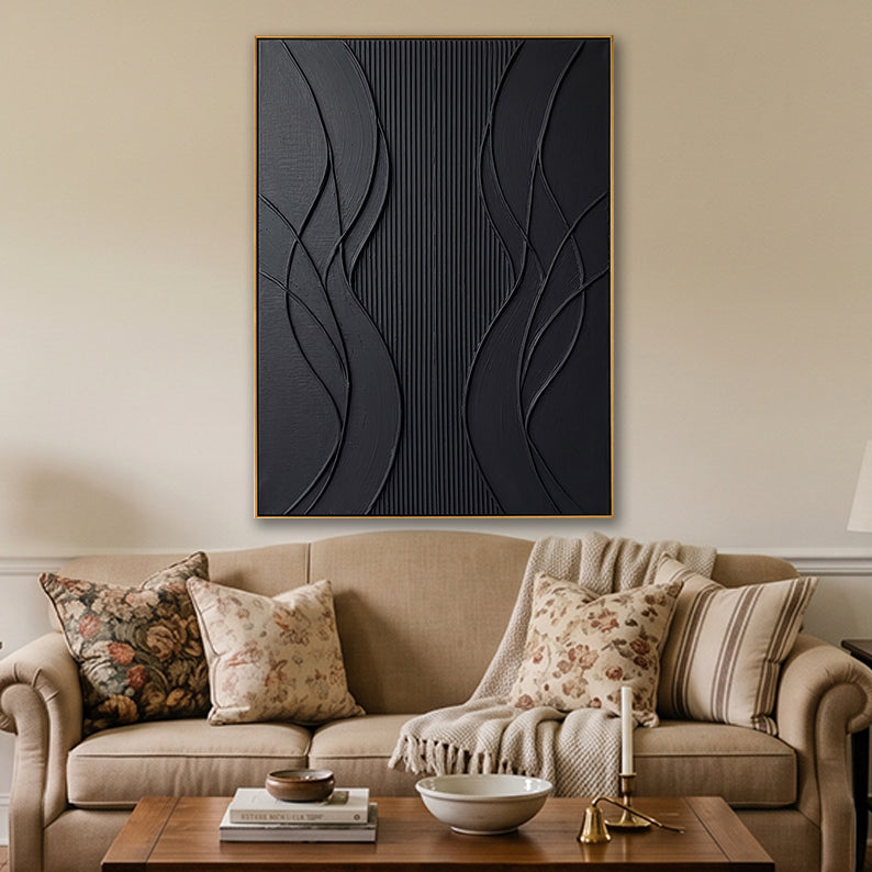 Hand-painted black abstract canvas in a cozy living room setup with neutral furniture and soft lighting.